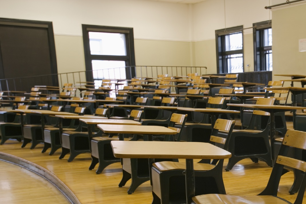 Picture of a college classroom with desks sitting in a semicircle