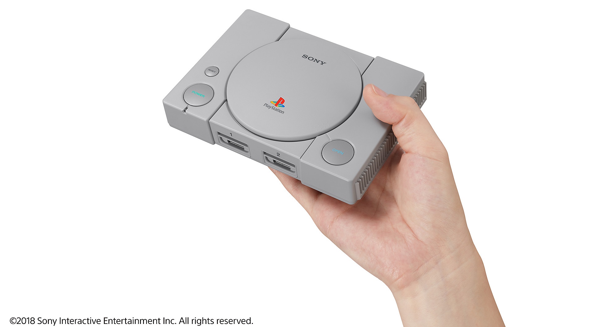 Hand holding the new PlayStation Classic console in front of a white background.